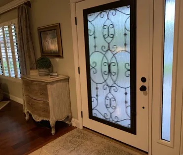 A door with a wrought iron design on the glass.