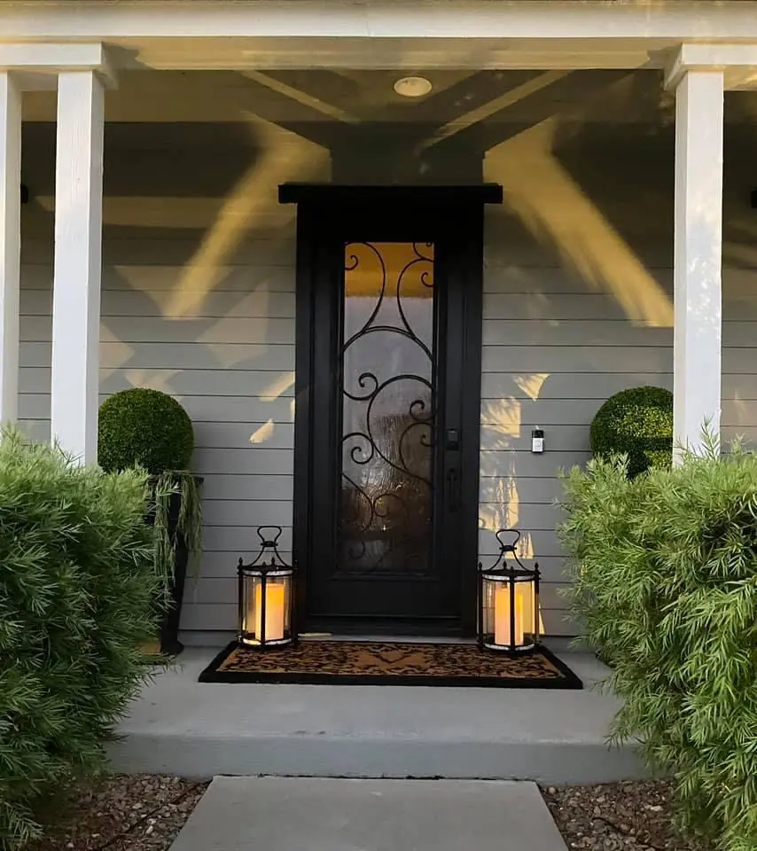 A front door between two floor lanterns