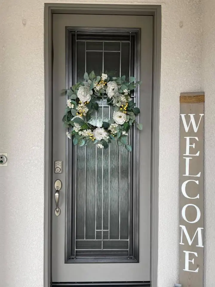 A welcome sign and wreath on the front door.