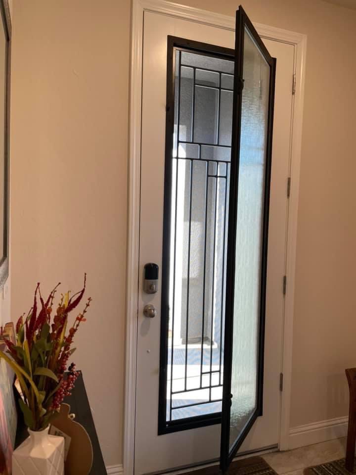 A door with a glass screen and a vase of flowers.