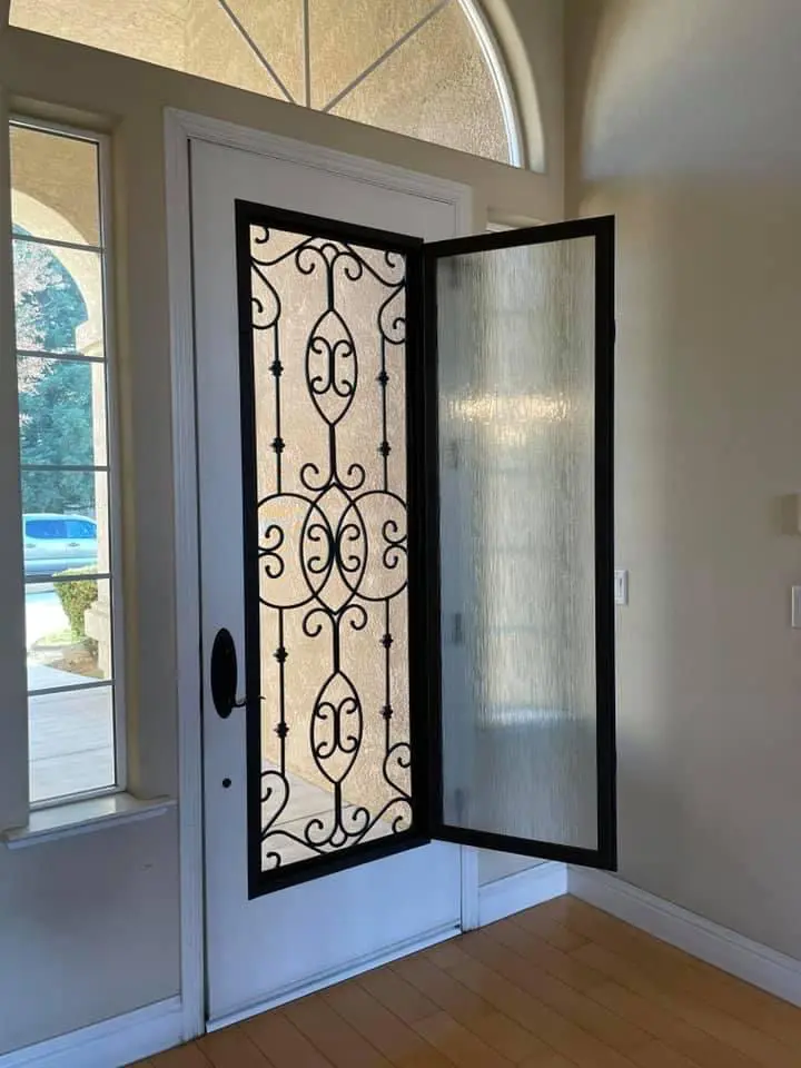 A door with a glass panel and iron work.